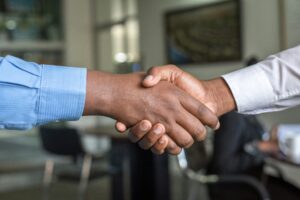 Two business professionals shaking hands, representing trust and relationship building in sales